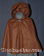 Cloak:2955, Cloak Style:Shaped Shoulder Cloak - Short, Cloak Color:Heathered Brown, Fiber / Weave:80% Wool / 20% Nylon, Cloak Clasp:Vale, Hood Lining:Unlined, Back Length:23", Neck Length:18.5", Seasons:Fall, Spring, Note:Perfect Starter cloak for a child<br>or a fashionable alternative<br>to a shawl for a youth.<br>This caramel flecked short cloak<br>is made of a hard finish melton wool<br>that is wind resistant to allow for<br>warmth during average winter months.<br>Because of this the fabric is less soft<br>and slightly stiffer than most cloaks.<br>This will lessen with use.<br>Accented with a silver tone vale<br> hook and eye clasp to complete<br>the look for cool evenings.<br>A fun addition to any wardrobe.<br>Dry Clean Only.<br>Pictured with robe R285 sold separately..