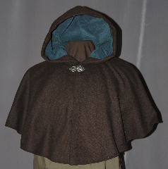 Cloak:2966, Cloak Style:Shaped Shoulder Cloak - Short, Cloak Color:Brown, Fiber / Weave:80% Wool / 20% Nylon, Cloak Clasp:Vale, Hood Lining:Teal Moleskin, Neck Length:19", Seasons:Fall, Spring, Southern Winter, Note:Perfect Starter cloak for a child or a<br>fashionable alternative to a shawl.<br>This dark brown short cloak is a<br>wool blend that is accented with<br>a silver tone vale hook and eye clasp<br>to complete the look for cool evenings.<br>A fun addition to any wardrobe.<br>Dry Clean Only..