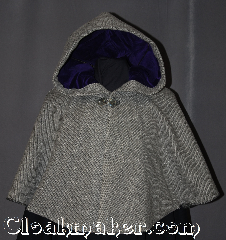Cloak:2996, Cloak Style:Short Full Circle, Cloak Color:Grey and Black Chevron, Fiber / Weave:50% Wool / 50% Silk, Cloak Clasp:Grey Mother of Pearl button, Hood Lining:Purple Cotton Velveteen, Back Length:21", Neck Length:26", Seasons:Fall, Spring, Southern Winter, Note:Dense and warm for cool evenings,<br>this grey and black chevron<br>short cloak is made of a<br>wool silk blend and will<br>stop people in their tracks.<br>One of a kind and machine washable<br>with a grey Mother of Pearl button and<br>two hand warmer pockets<br>on the inside for added comfort.<br>The hood is lined in a<br>rich jewel tone purple<br>made of soft cotton velveteen<br>for a perfect addition to any outfit..