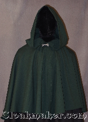 Cloak:3023, Cloak Style:Short Shape Shoulder Cloak<br> youth with liripipe, Cloak Color:Green, Fiber / Weave:100% Lt Weight Gabardine Wool, Cloak Clasp:Stina Pewter, Hood Lining:Unlined, Back Length:25.5", Neck Length:19.5", Seasons:Summer, Fall, Spring, Note:Made of a light weight gabardine<br>wool this green short shaped<br>shoulder cloak is perfect<br>for a youth starter cloak<br>will fit longer than a<br>coat as they grow.<br>Features a lirepipe hood,<br>great for use as a scarf or storage,<br>adorned with a silver<br>alpine knot hook-and-eye clasp.<br>Dry clean only.