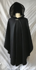 Cloak:3773, Cloak Style:Shaped Shoulder Ruana, Cloak Color:Black, Fiber / Weave:80% wool, 20% nylon, Cloak Clasp:Vale, Hood Lining:Mousy grey cotton velveteen, Back Length:42", Neck Length:24", Seasons:Winter, Southern Winter, Spring, Fall, Note:Travel in this black wool blend ruana<br>style cloak with a silvertone vale clasp<br>and a mousy grey cotton<br>velveteen hood lining.<br>Great for driving, designed to<br>have less bulk.<br>Dry clean only..