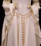 A woman's coin or chain belt made of gold tone metal pieces belting a custom order recreation accolade gown in ivory white.