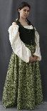 A woman models a historical recreation of a brown and green Irish bodice dress with lace up front.