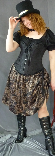 A woman modelling a steampunk outfit, which consists of a black top hat, a black overbust corset worn over a black blouse and a brown pattern modern Victorian skirt.