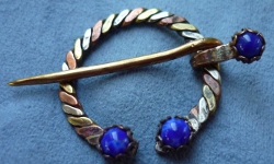 Tri-colored twisted Penannular with blue
                        stones